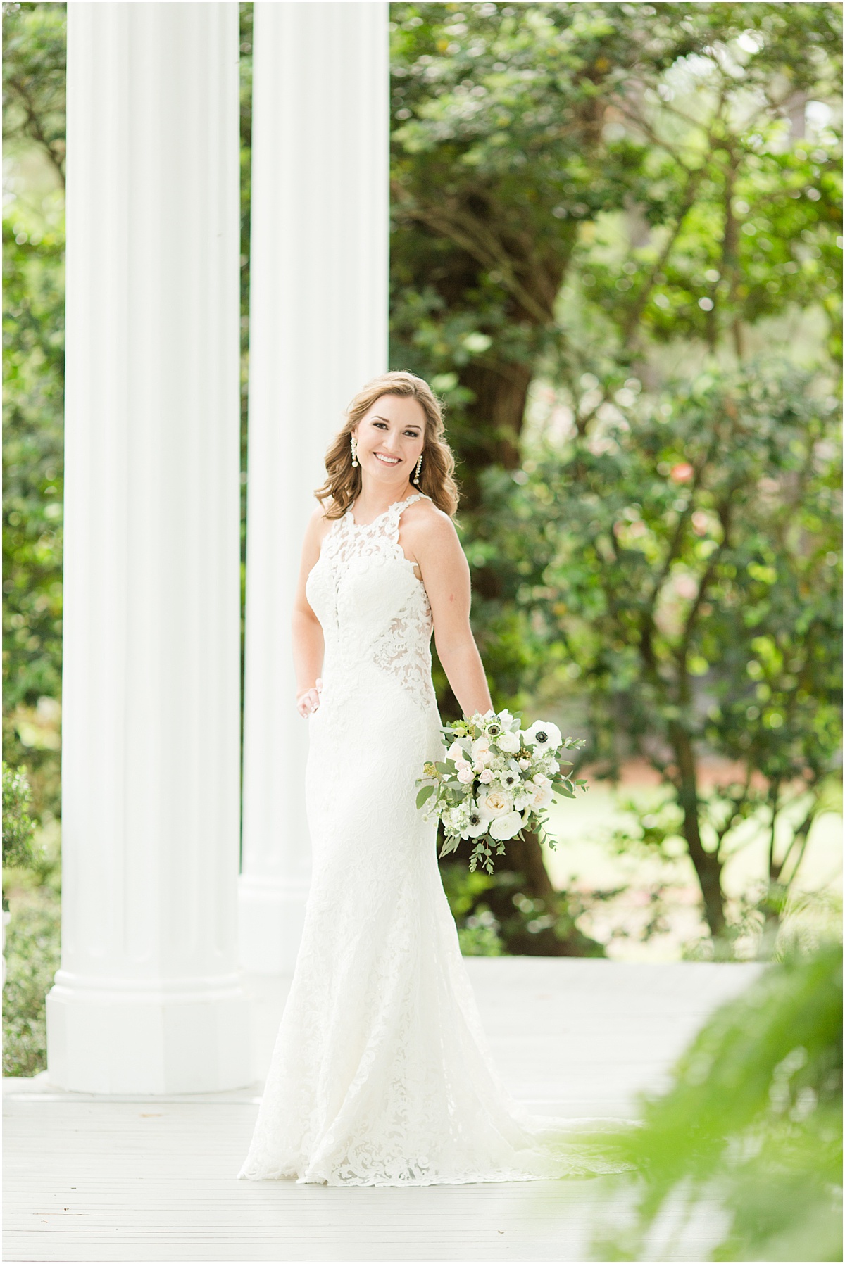 Bride wearing a lace gown standing on the porch at the Bragg-Mitchell Mansion in Mobile Alabama