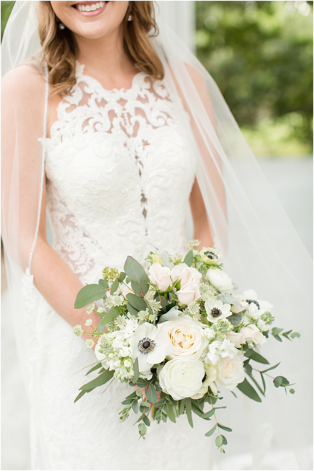 A spring bridal bouquet with creamy pink and peach roses, anemones and greenery.