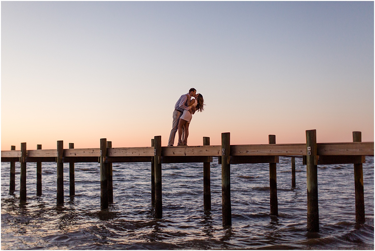 A man and woman kissing on Fairhope Pier at sunset in Fairhope Alabama.