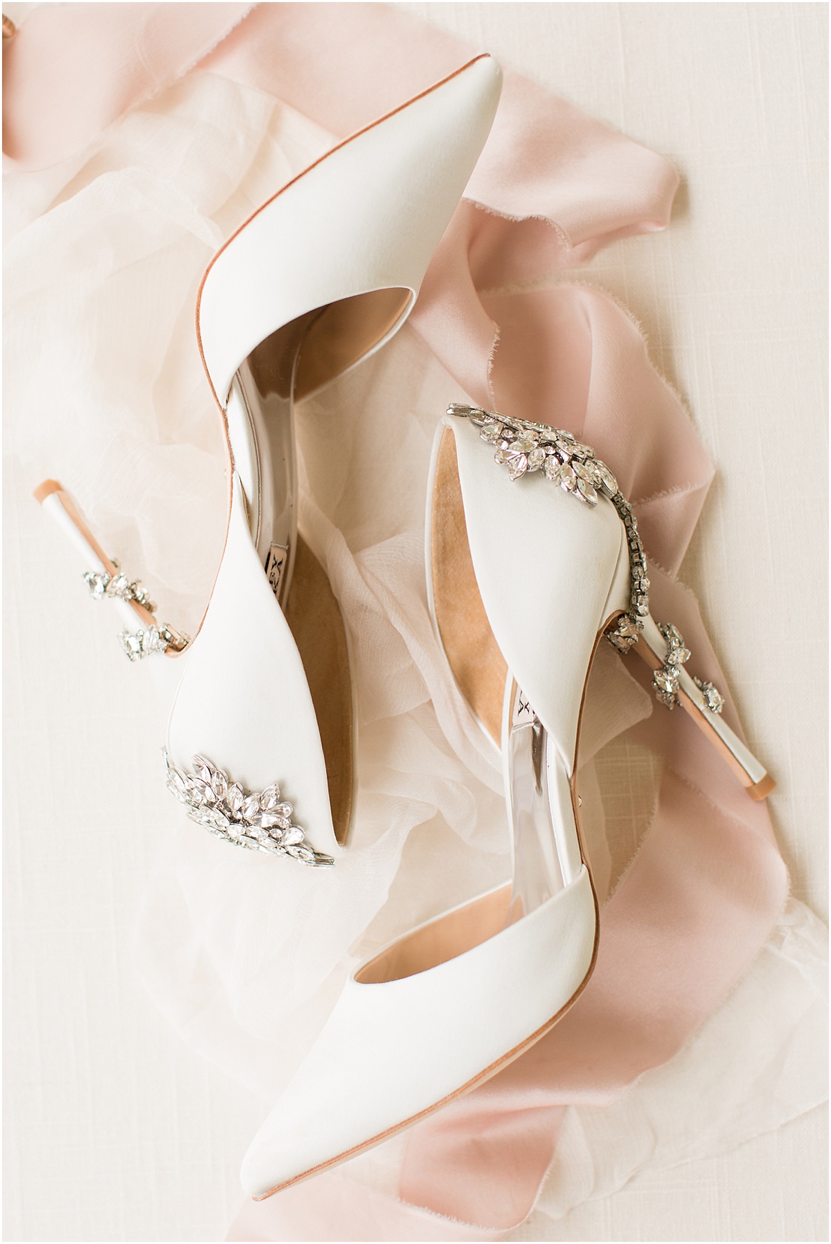 White Badgley Mischka bridal shoes with blush pink ribbon